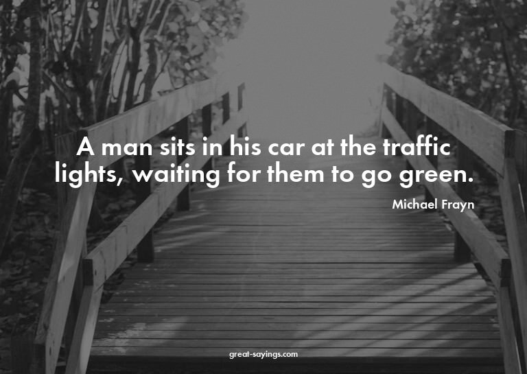 A man sits in his car at the traffic lights, waiting fo